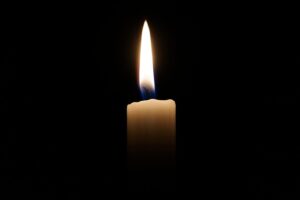 close up image of a lighted candle on a dark background