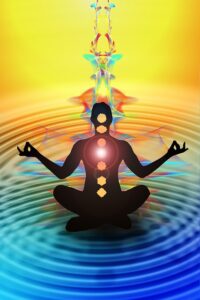 artistic representation of a person in a meditative pose, seated in a lotus position with hands in a mudra, and glowing circles are placed along the body, representing the seven chakras