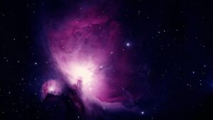 A wide shot of a vibrant purple and pink nebula, filled with glowing gas and numerous stars