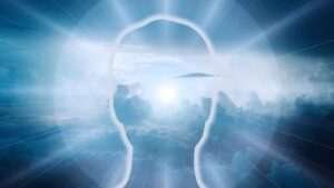 A conceptual image showing the silhouette of a human head with a bright, cloudy sky and sun inside of it. Beams of light radiate outward from the head
