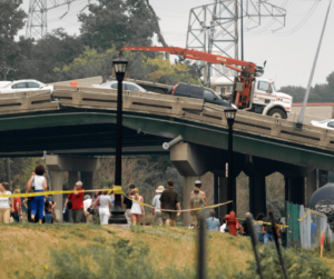 collapsed bridge with many onlookers below