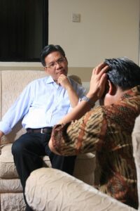 two men engaged in what appears to be a counseling session