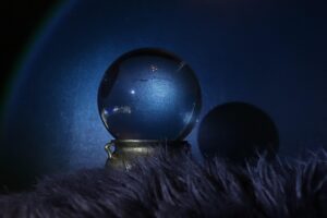 A crystal ball on a dark, fuzzy surface with a blue background