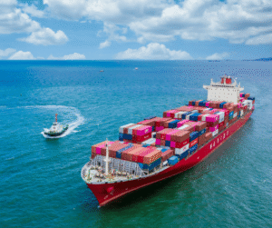 A large cargo ship carrying colorful shipping containers travels across the sea.