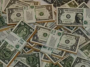 a large quantity of one-dollar bills, both individually scattered and bundled into stacks