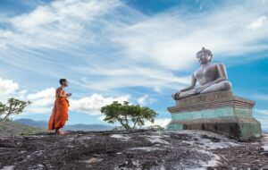 monk looking at Buddha statue