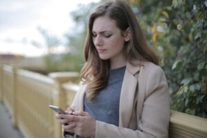woman looking worried while glancing at her phone