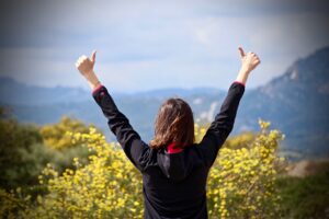 woman with raised hands showing positive energy