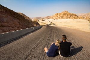 couple sitting in the middle of a road
