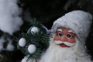 festive Santa Claus figurine with a white fluffy hat and beard, round glasses, and rosy cheeks