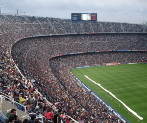 A packed football stadium with thousands of spectators watching a match.