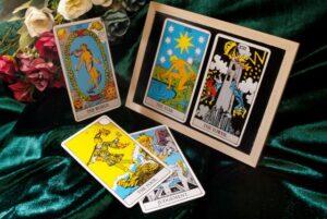 still life composition featuring several classic Rider-Waite tarot cards,