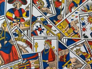 A scattered arrangement of various traditional Marseille tarot cards