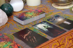 a mystical setup with a spread of illustrated tarot cards on an embroidered fabric surface