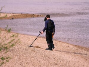 man doing treasure hunt by the beach
