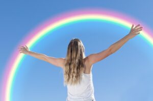 young woman embracing rainbow