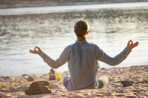 yoga man doing meditation beach