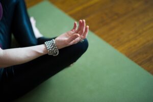 a close-up, high-angle shot focusing on a person's hand and arm in a yoga or meditation pose
